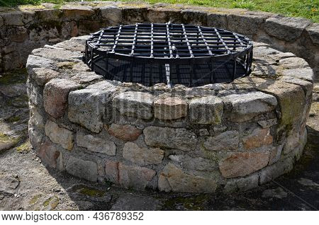 Stone Round Fountain With A Protective Grid Of Twisted Prisms. Forged Steel Bars Go Spiraled At The 