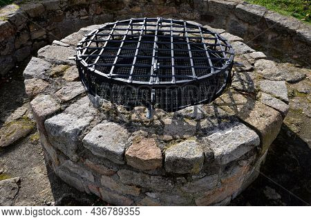 Stone Round Fountain With A Protective Grid Of Twisted Prisms. Forged Steel Bars Go Spiraled At The 