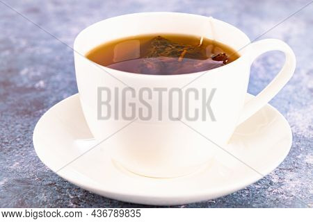Steeping A Herbal Tea Bag In A Porcelain Cup Close Up