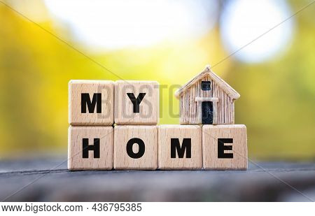Text My Home Made Of Wooden Letter Blocks And A Tiny Toy House Standing On A Tree Stump Against A Bl
