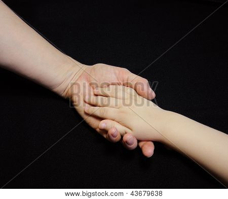 Madre dando la mano a un bambino su sfondo nero