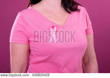 Midsection of caucasian woman in pink tshirt with ribbon. breast cancer positive awareness campaign concept digitally generated video.