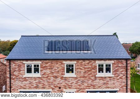 A New Build Home With Built In Photovoltaic Solar Panels In The Roof Generating Clean And Renewable 