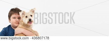 Young Boy Holds His Dog In His Arms. Subject Isolated From The Background. Panoramic Frame.