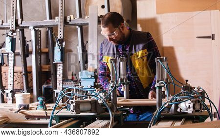 Professional Carpenter Working At Woodwork Factory With Pneumatic Press