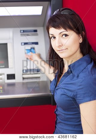 Mulher de retirar o dinheiro do cartão de crédito em caixa eletrônico