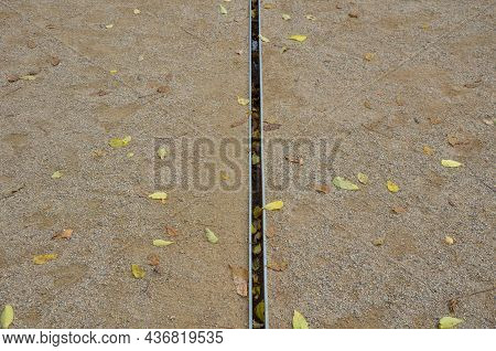 Park Square With Gravel Compacted Paths And Concrete Sidewalk. A Metal Slot Gutter Is Used For Drain
