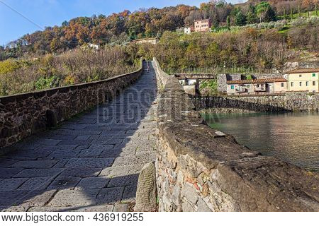 Picturesque stone bridge built a thousand years ago. Devil's Bridge over the Sercchio River. Cold windy winter day. Travel to fabulous Italy. 