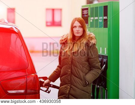 Young Caucasian Woman At Self-service Gas Station, Hold Fuel Nozzle And Refuel The Car With Petrol, 
