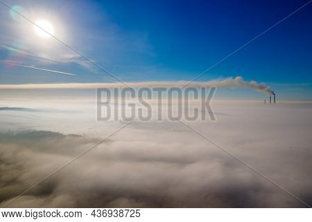 Aerial View Of Winter Landscape With Foggy Countryside And Distant Factory Pipes Emmiting Black Dirt