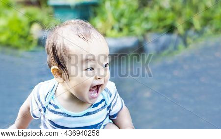 Boy Cries In A Loud Voice And Is Excited Outdoors. The Baby Boy Emit Energy From His Body.
