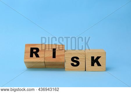 Wooden Cubes With Word Risk On Light Blue Background