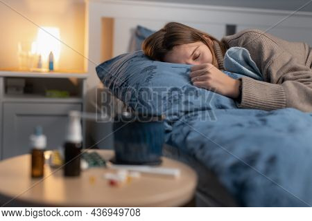 Illness Girl Sleeping In Bed. Near Table With Various Medicines And Pills. Woman Got The Flu Or A Co