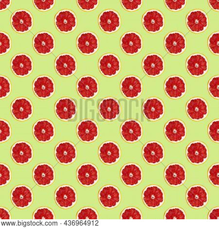 Fresh Grapefuit Slices Seamless Pattern Over Green Background, Top View