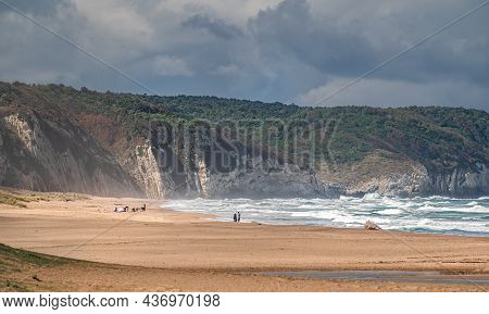 Beautiful Sandy Ocean Beach With Large Rocks On Shore And In The Water. Powerful Waves On Ocean. Oce