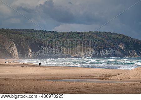 Beautiful Sandy Ocean Beach With Large Rocks On Shore And In The Water. Powerful Waves On Ocean. Oce