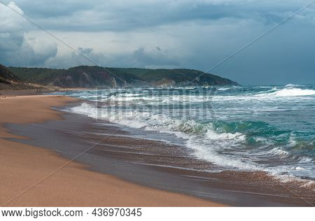 Beautiful Sandy Ocean Beach With Large Rocks On The Shore And In The Water. Powerful Waves On Ocean.