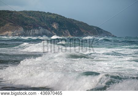 Beautiful Sandy Ocean Beach With Large Rocks On The Shore And In The Water. Powerful Waves On Ocean.