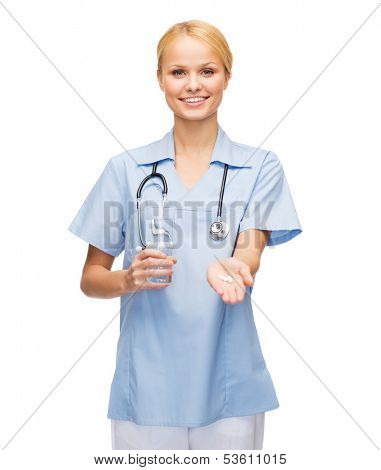 healthcare, medicine and pharmacy concept - smiling doctor or nurse with stethoscope offering pills and glass of water