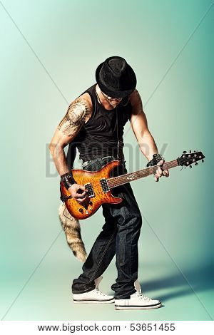 Rock musician is playing electrical guitar.