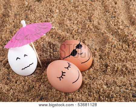 Easter Funny Eggs Under Umbrella On A Sand