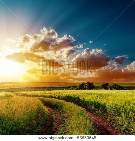 dramatic sunset over road in fields