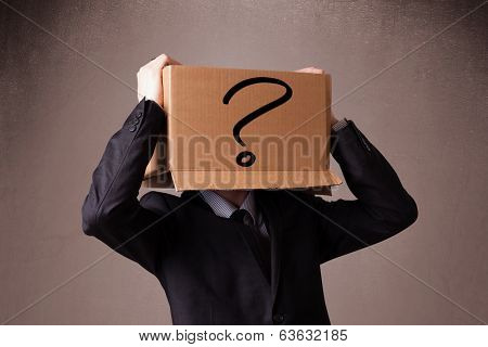 Businessman standing and gesturing with a cardboard box on his head with question mark