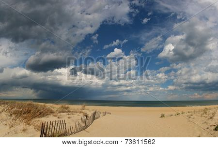 Sandy beach with blue sky and fence