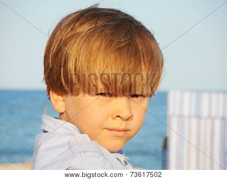 Portrait of an adorable little boy on a background of the sea.