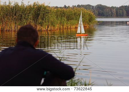 man watching a radio-controlled boat