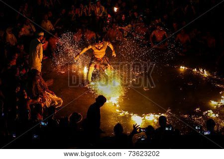 BALI, INDONESIA - SEPTEMBER 19, 2014: Hanuman puts out the fire during a performance of the traditional Balinese Kecak Fire Dance at the Uluwatu Temple in Bali. 
