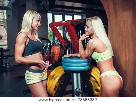 athletic young women resting during exercise in the gy