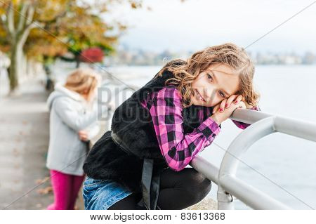 Two girls playing by the lake outdoors
