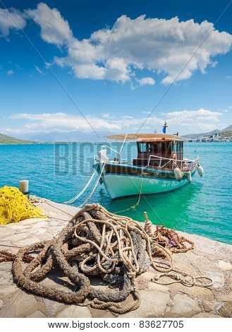 Fishing Boat Off The Coast Of Crete With Marine Rope And Fishing Net In The Foreground