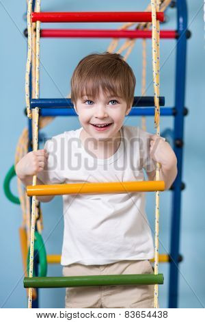Kid boy climbing a rope ladder