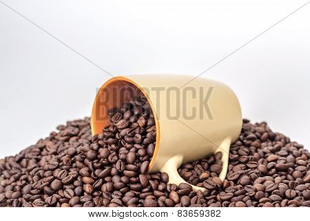 ceramic orange mug on a pile of roasted coffee beans