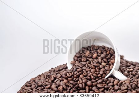 ceramic white mug on a pile of roasted coffee beans