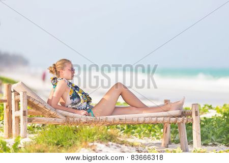 Woman sunbathing on tropical beach.
