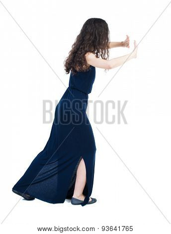 back view of woman pushes wall. Isolated over white background. Rear view people collection. backside view of person.  Girl in a blue evening dress is pushing the right wall.