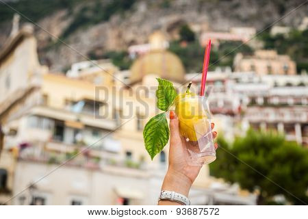 Girl's hand holding a glass with lemon ice cream.