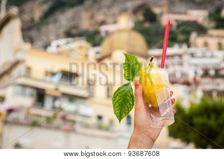 Girl's hand holding a glass with lemon ice cream.