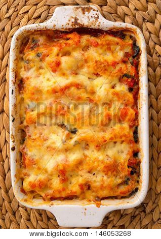 Baked chicken fillets with mozzarella in casserole. Shot from above