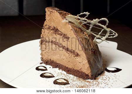 piece of chocolate cake on a white plate, decorated