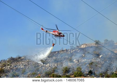 August 21 2016-Monti Prenestini-Castel San Peter- Roma-Lazio-Italy-the helicopter of the fire brigade to put out an arson attack on the slopes Prenestini who is skirting the first inhabited houses