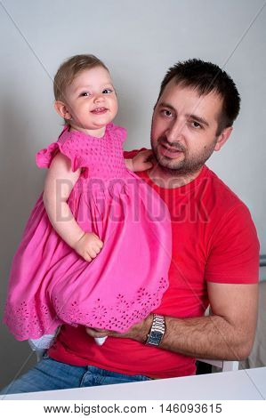 Father and daughter. Happy young father holding his smiling daughter