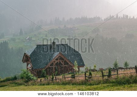 Old wooden house under rain in mountain. cheese dairy. Carpathians Ukraine