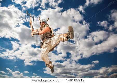 crazy strong viking with traditional costume attacking from sky. looking at camera with angry eyes.