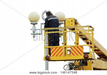 Isolated Electrical worker repairing the wires on the pole with the help of the lift car