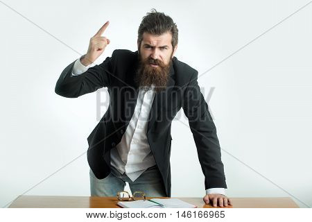 young handsome bearded angry man scientist or professor with long beard and teacher glasses with book or notepaper at table isolated on white background