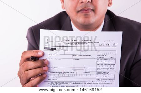 indian businessman showing indian income tax return form or ITR-4 form or form no. 16 of income tax department of india, selective focus